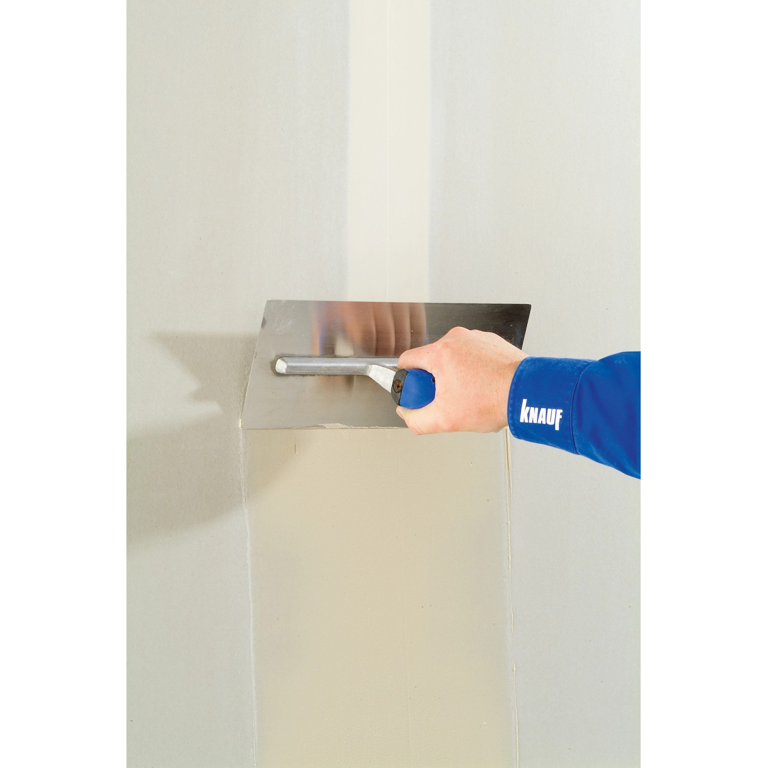 Auftragen von Knauf Fugenfüller Leicht auf eine Wand mit einer Spachtel.