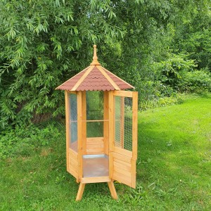 Sechseckige Promadino Vogelvoliere aus Holz mit Bitumendach und geöffneter Tür im Garten.