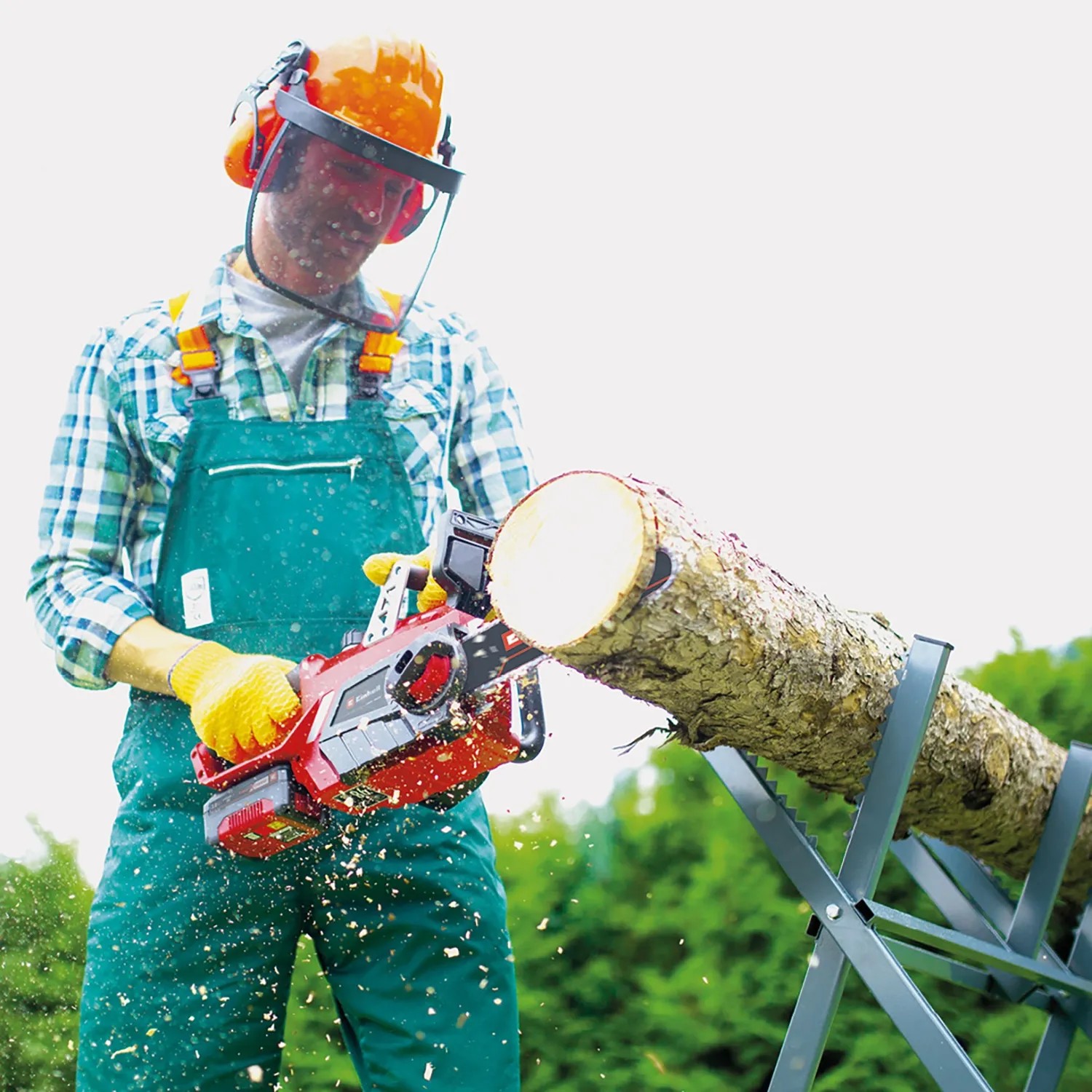 Einhell Akku-Kettensäge GE-LC 18 Li Kit beim Sägen von Holz auf einem Sägebock.