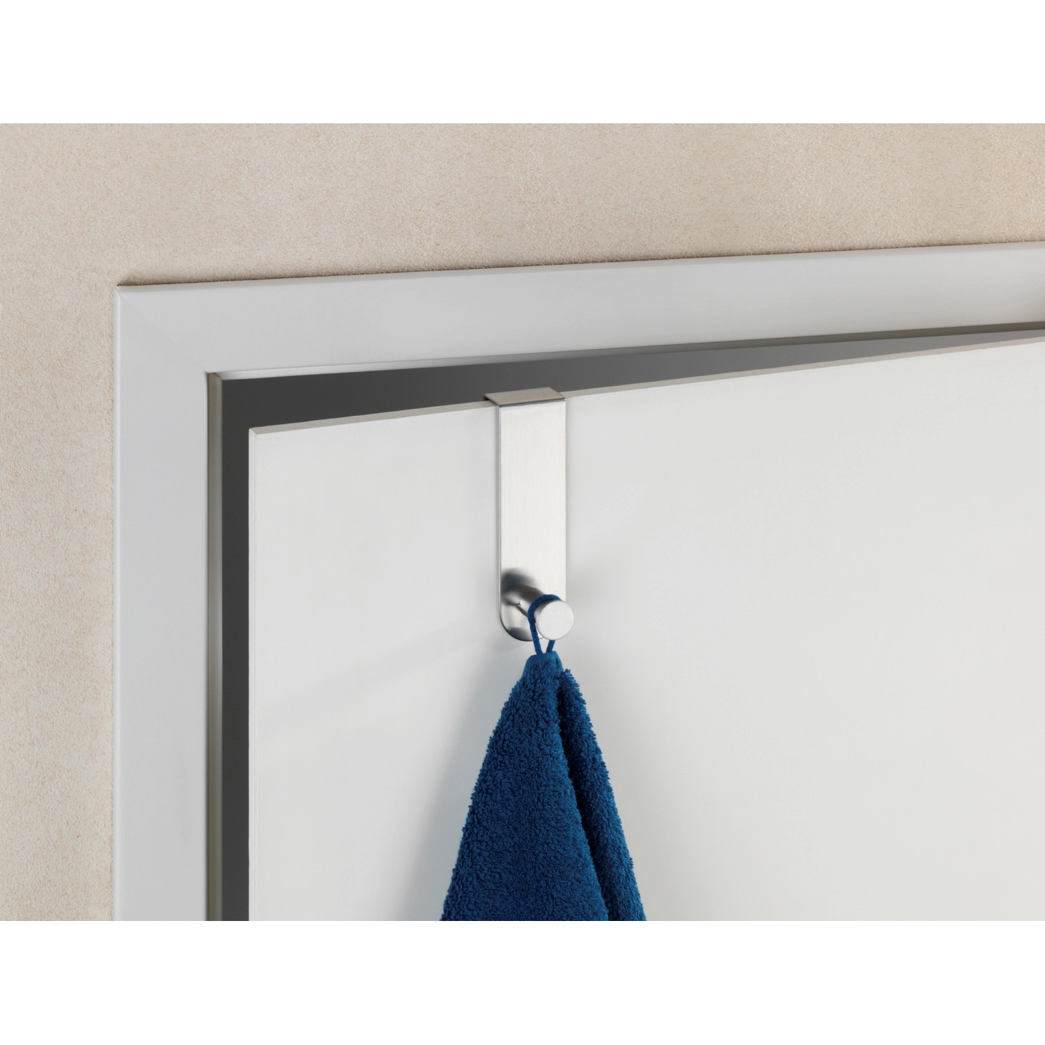 Wenko Türhaken Celano aus Edelstahl mit blauem Handtuch an weißer Tür.