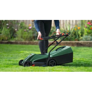Person mäht Rasen mit grünem Bosch Easy Rotak 32-215 Elektrorasenmäher. Klappbare Griffe für einfache Handhabung im Garten.