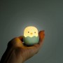 Grünes MegaLight LED-Nachtlicht Baby Eggy mit Akku in Hand gehalten.