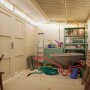 Innenansicht: Unbehandeltes Palmako Holz-Gartenhaus mit Pultdach und Gartengeräten.