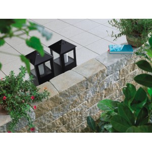 Mauer aus Vigneto Mauersteinen in Sandsteingelb mit Laternen und Pflanzen.