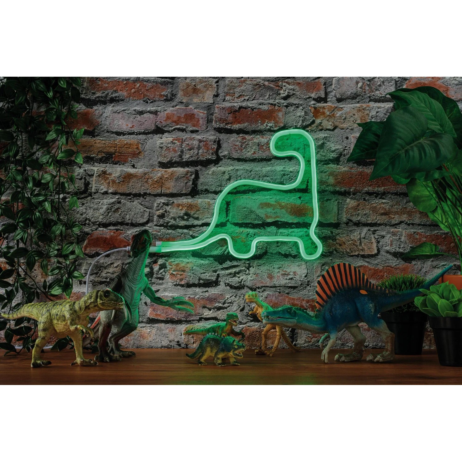 Paulmann LED Strip Neon Colorflex Grün, Dinosaurier-Form, mit Deko-Dinos vor einer Backsteinwand.