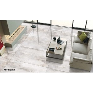 Verlegtes, glänzend poliertes Feinsteinzeug "Silber" 60x60 cm im Wohnraum mit Sofa und Kamin.