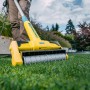 Gloria MultiBrush XL Elektro-Oberflächenbürste im Einsatz auf Rasen. Gartenhandgerät mit rotierender Bürste.