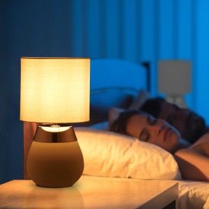 Elegante Relaxdays Tischlampe mit hellem Stoffschirm und dunklem Fuß mit Silberring, spendet warmes Licht im Schlafzimmer.