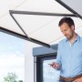 Mann steuert per Funk den Schellenberg Markisenmotor Premium 50 für Hausautomation.