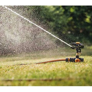 Fiskars Impulsregner mit Erdspieß bewässert Rasenfläche. Sprinkler-System für Garten.