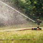 Fiskars Impulsregner mit Erdspieß bewässert Rasenfläche. Sprinkler-System für Garten.
