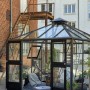 Juliana Gewächshaus Oase 8 Anthrazit mit Glas, begehbar, mit geöffneten Türen und Pflanzen.