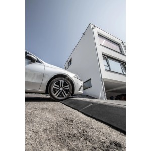 Terrasoft Bordsteinrampe XL im Einsatz: Auto fährt über Rampe auf Bordstein. Baugerät für leichteres Auffahren.