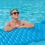 Mann entspannt auf blauer Bestway Luftmatratze Float'n Roll im Pool.