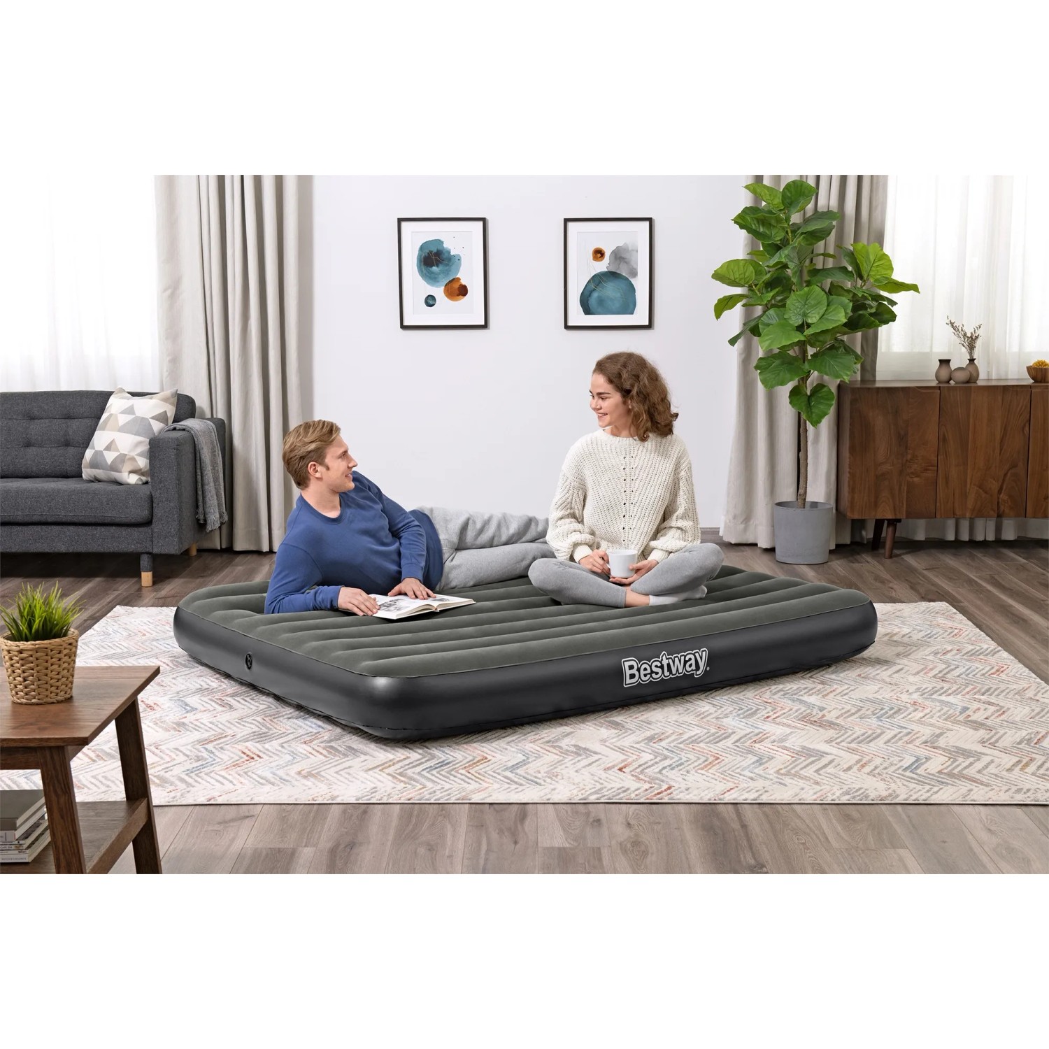 Bestway TriTech Luftbett für 1 Person, 185x76x25 cm, mit zwei Personen im Wohnzimmer.