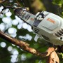 Stihl Akku-Hochentaster HTA 86 in Grau-Orange schneidet einen Ast. Kettensäge für Baumpflege im Einsatz.