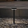 Schwarze Lindby LED Solarleuchte Brinca mit Bewegungsmelder im Garten.