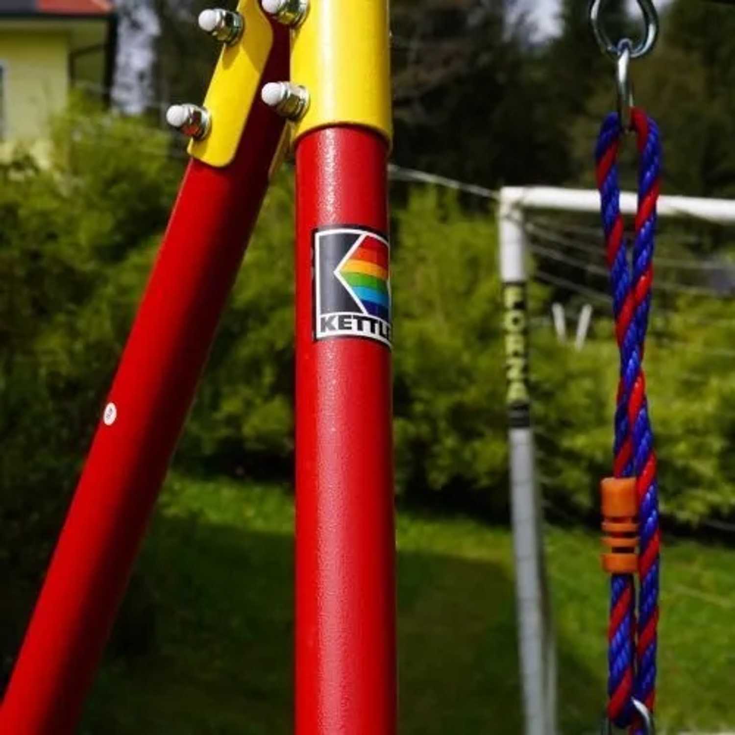 Detailaufnahme Kettler Einzelschaukel in Rot/Blau mit gelbem Rahmen.
