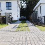 Steingraue HL Drainpflaster Füllsteine in Rasengitter auf einer PKW-Einfahrt.