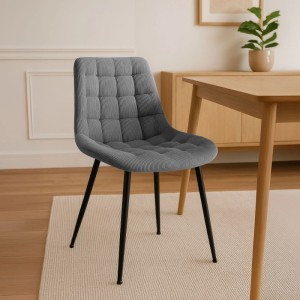 Grauer CLP Esszimmerstuhl Sardna aus Cord mit Steppmuster und schwarzen Metallbeinen am Holztisch.