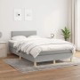Helles Boxspringbett 120x200 cm mit Matratze, hellgrauer Stoffbezug, Holzfüße.