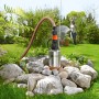 Gardena Premium Tiefbrunnenpumpe 6000/5 inox im Garten mit Schlauch und Bewässerung im Hintergrund.