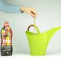 Nutri One Universal-Dünger Flüssigkonzentrat neben grüner Gießkanne bei der Anwendung.