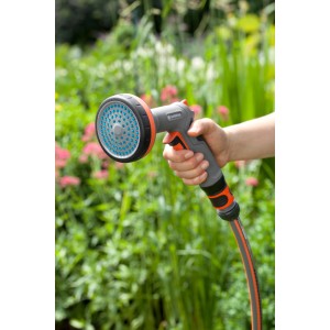 Gardena Comfort Beetbrause in Nutzung: Hand hält graue Gartenbrause mit blauem Brausekopf vor grünem Beet.