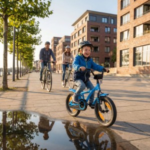 Fröhlicher Junge fährt blaues PROMETHEUS Kinderfahrrad 14 Zoll mit Familie auf dem Bürgersteig.