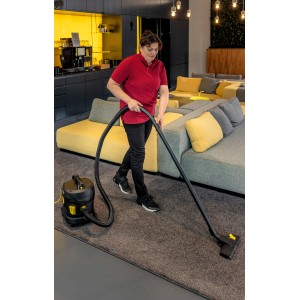 Frau saugt mit Kärcher T 11/1 Classic Adv Trockensauger Teppich. Kompakter, leiser Gewerbesauger.