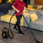 Frau saugt mit Kärcher T 11/1 Classic Adv Trockensauger Teppich. Kompakter, leiser Gewerbesauger.