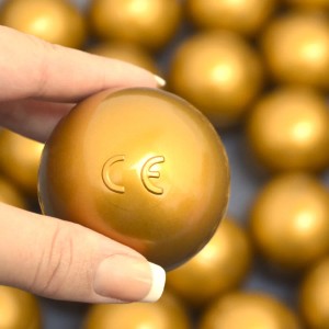 Goldener Bällebadball (5.5 cm) von LittleTom, gehalten in einer Hand. Bällebad Zubehör für Spiel & Spaß.