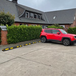 UvV Ecopark Radstopper 180cm, schwarz-weißer Anfahrschutz aus Recyclingmaterial vor rotem Auto.