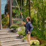 Mann reinigt Fenster mit Gardena Cleansystem Teleskop-Stiel M-XL Anthrazit.