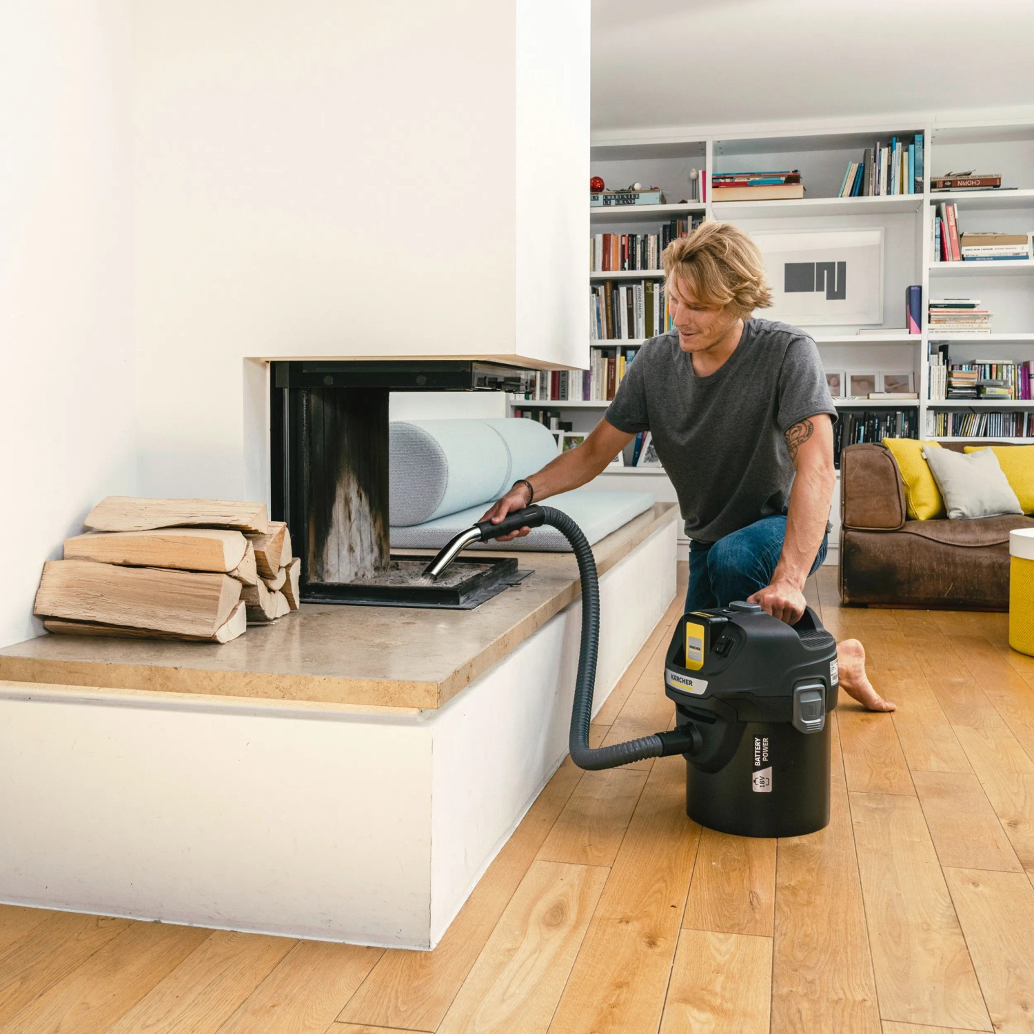 Mann saugt Asche mit dem Kärcher Akku-Aschesauger AD 2 aus einem Kamin.