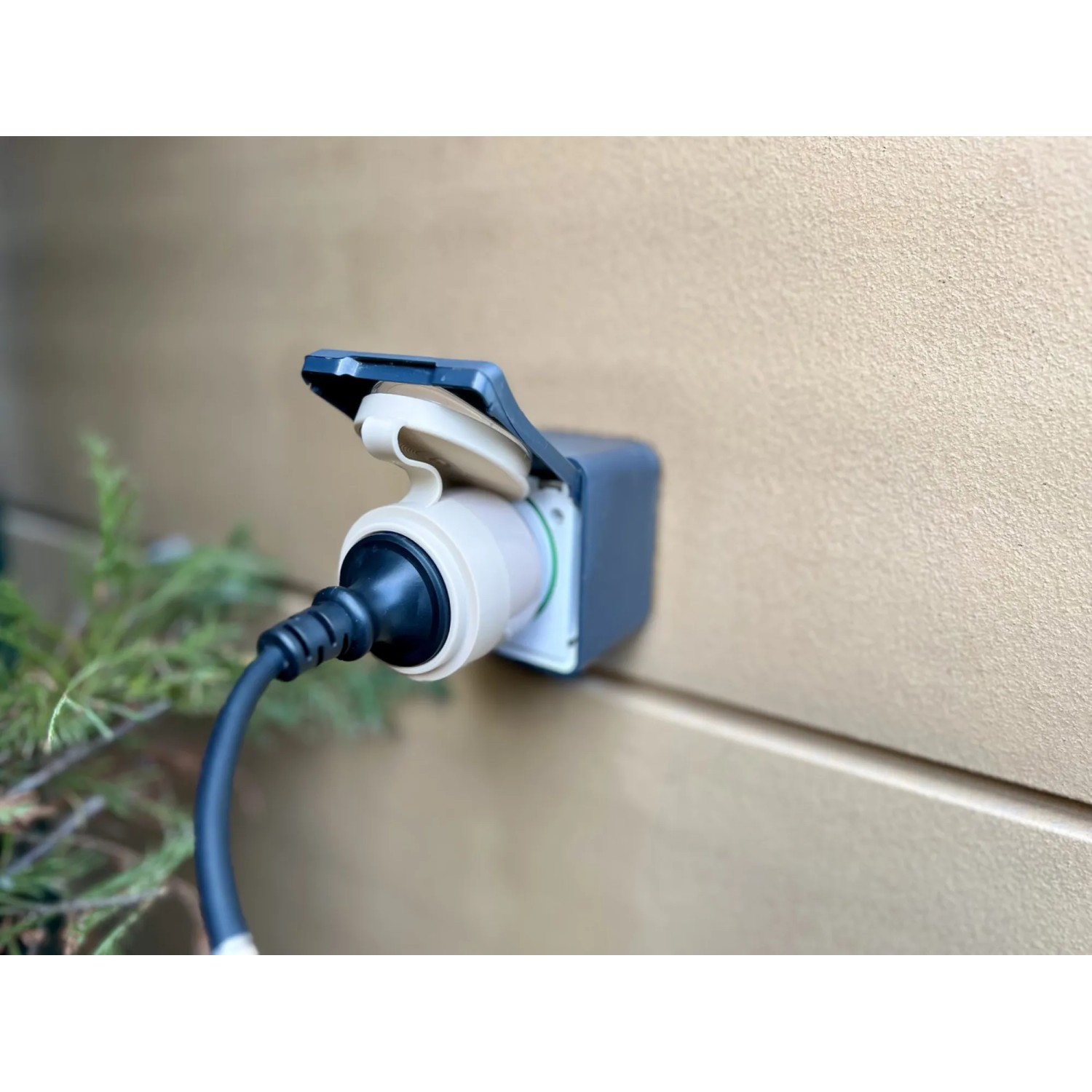 Shelly Smart-Stecker Outdoor Plug S Gen3 Beige an Hauswand, für die Hausautomation im Außenbereich.