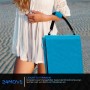 Zusammengeklappte blaue 24MOVE Strandmatte mit Tragegurt, getragen von einer Person am Strand.