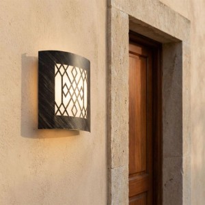 Moderne QAZQA Emmerald Außenwandleuchte, rostbraun, mit geometrischem Muster, leuchtet an Hauswand neben Holztür.