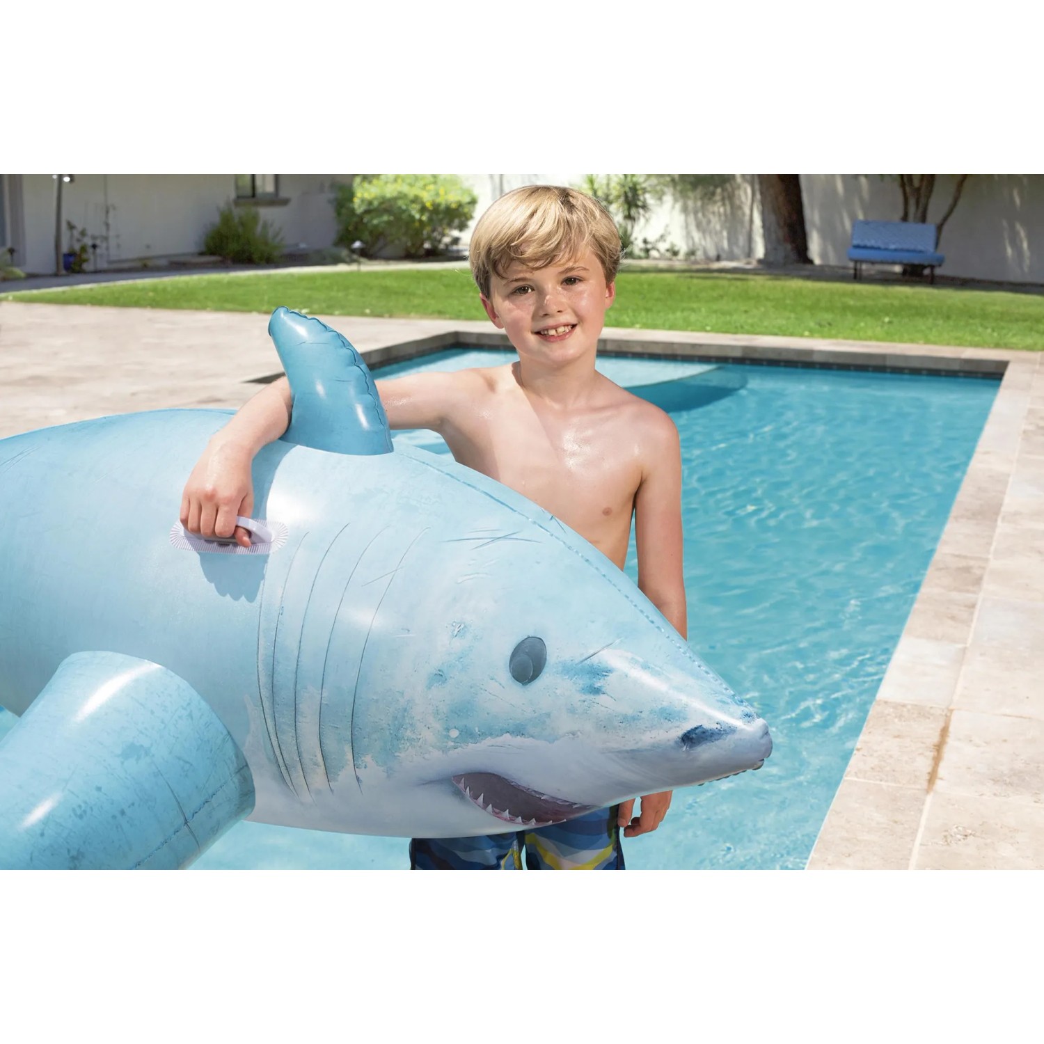 Kind mit blauem Bestway Schwimmtier Hai im Pool, 178x98x53 cm.