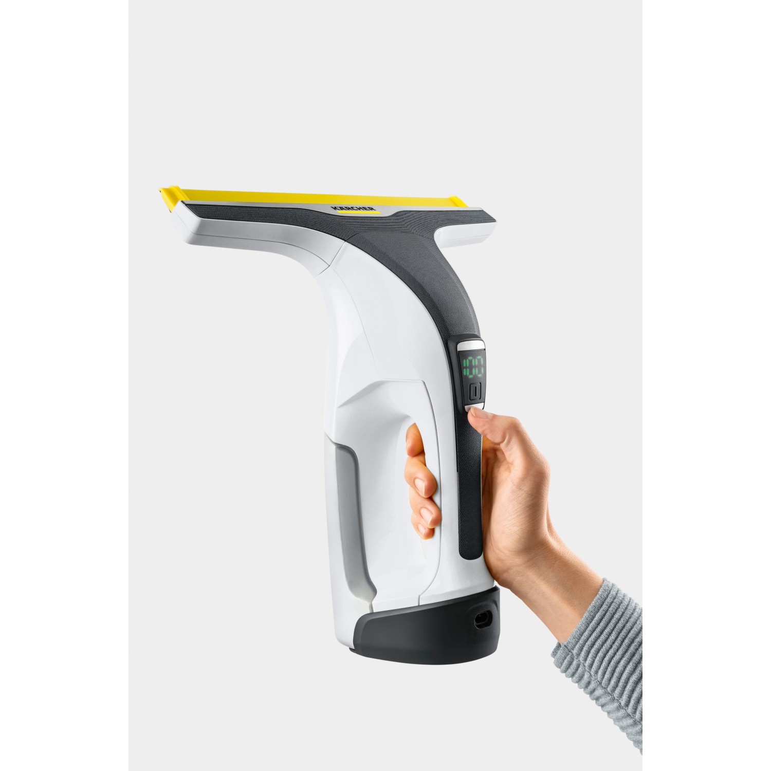 Hand hält Kärcher Akku-Fenstersauger WV 6 Plus, weiß/grau mit gelber Lippe. Digitale Akkuanzeige.