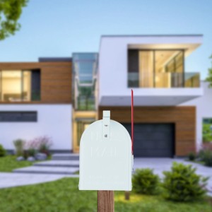 Weißer US Briefkasten aus Stahl mit roter Fahne, montiert vor einem modernen Haus.