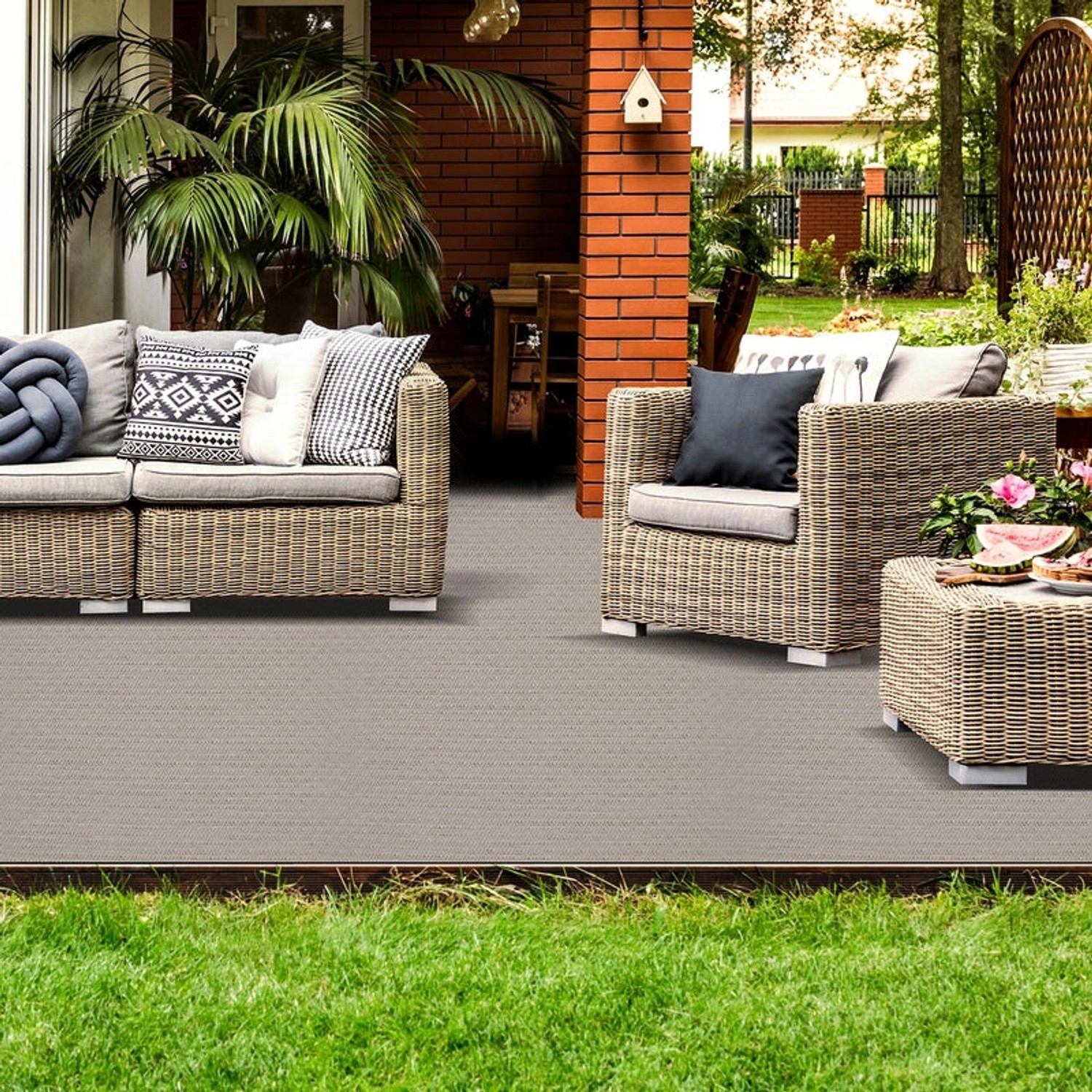 Terrasse mit grauem Outdoor Teppich Turin und Gartenmöbeln.