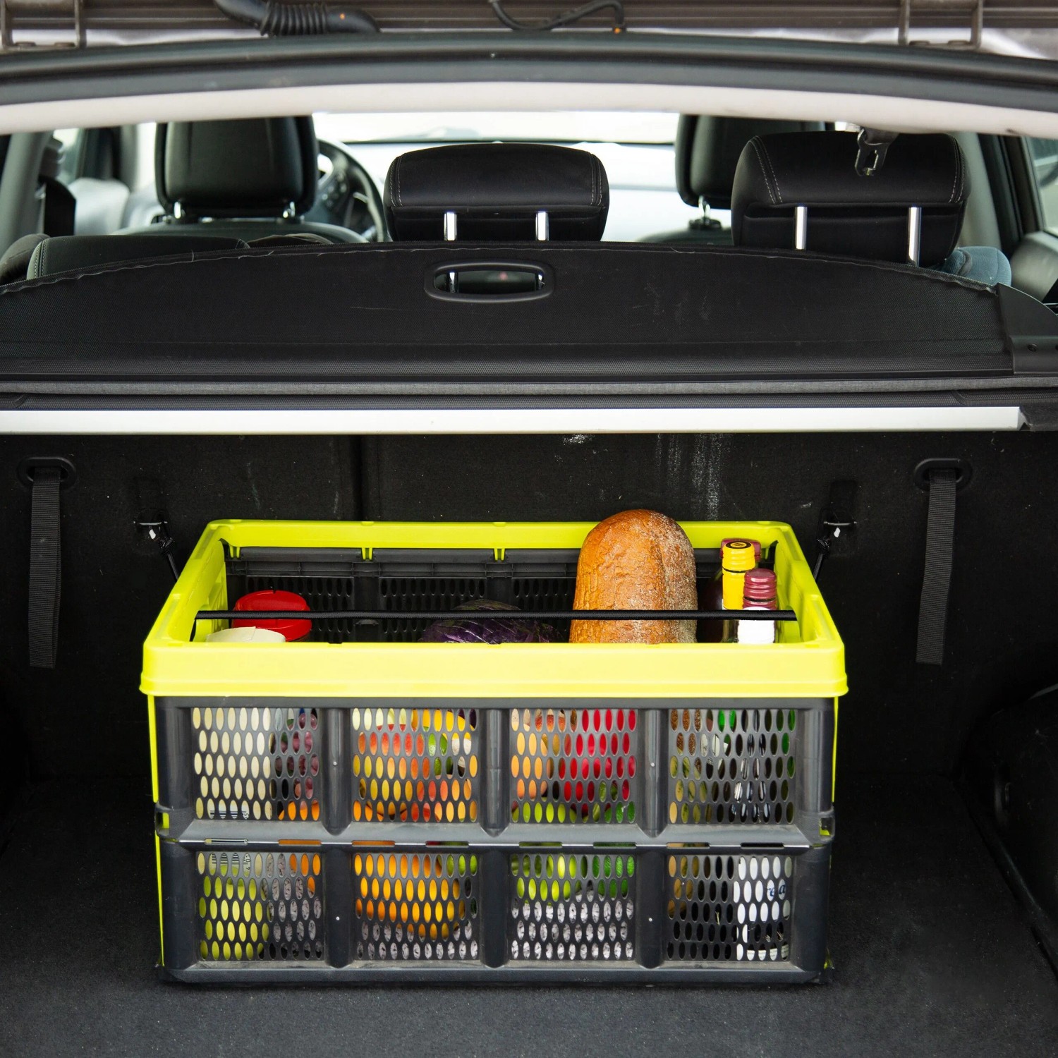 Gelb-schwarze Faltbox mit Lebensmitteln im Kofferraum eines Autos. Ideal zur Gepäcksicherung und für den Transport von Einkäufen.