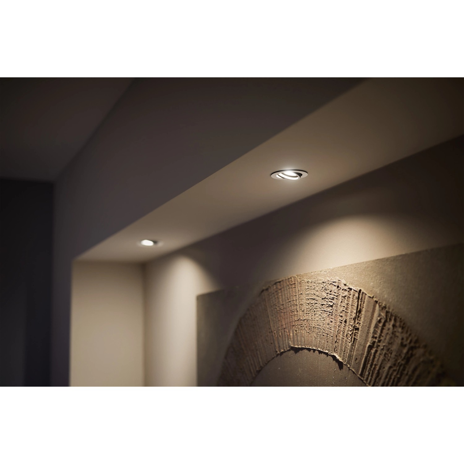 Zwei runde, weiße Philips Hue Centura LED-Einbauspots in Decke mit warmweißem Licht.