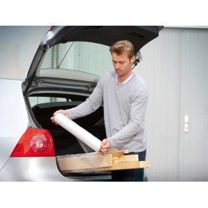 Mann verpackt Holz mit LUX Stretchfolie (0,5 m x 120 m) im Kofferraum.