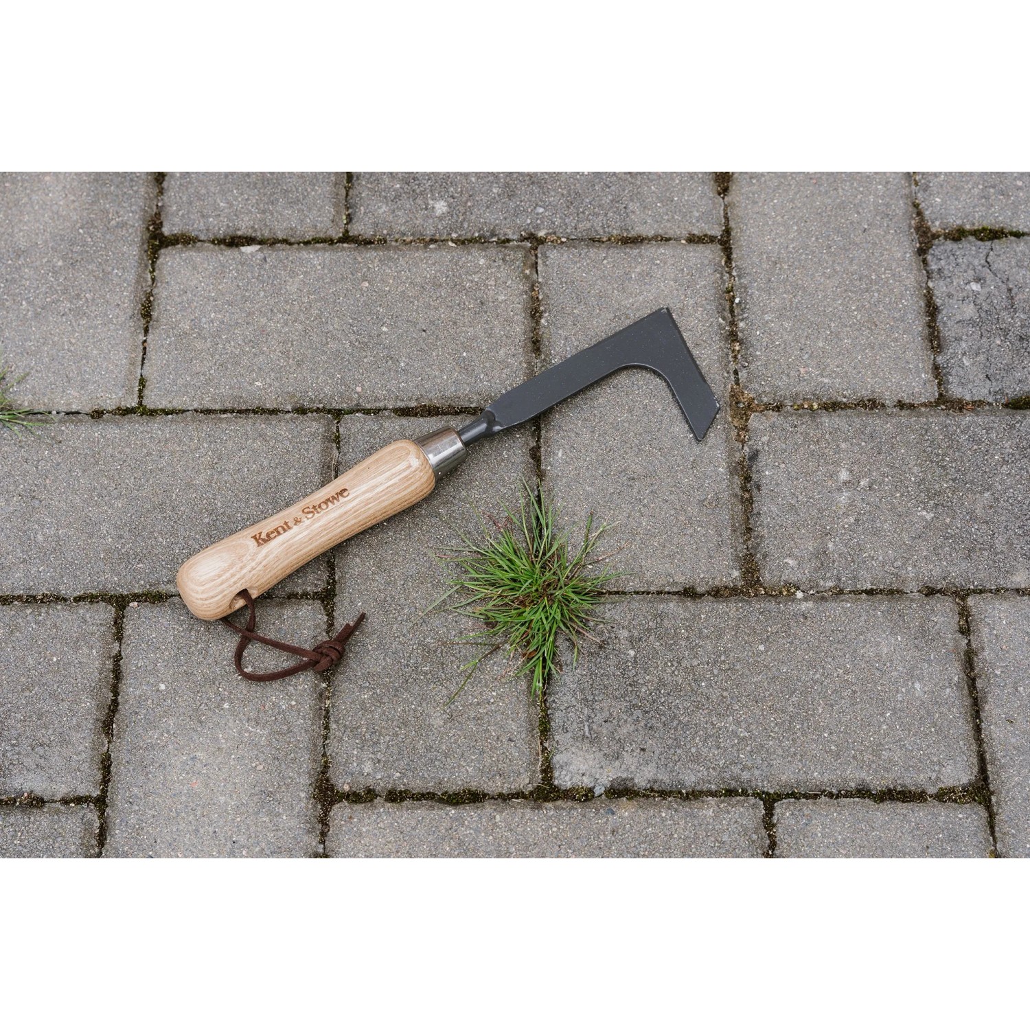 Kent & Stowe Fugenkratzer Carbon Steel FSC® auf Pflastersteinen mit Unkraut.