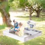 roba Sandkasten aus grau lasiertem Holz mit Matschküche, spielenden Kindern, Sitzbänken, Herdplatten und Wasserhahn.