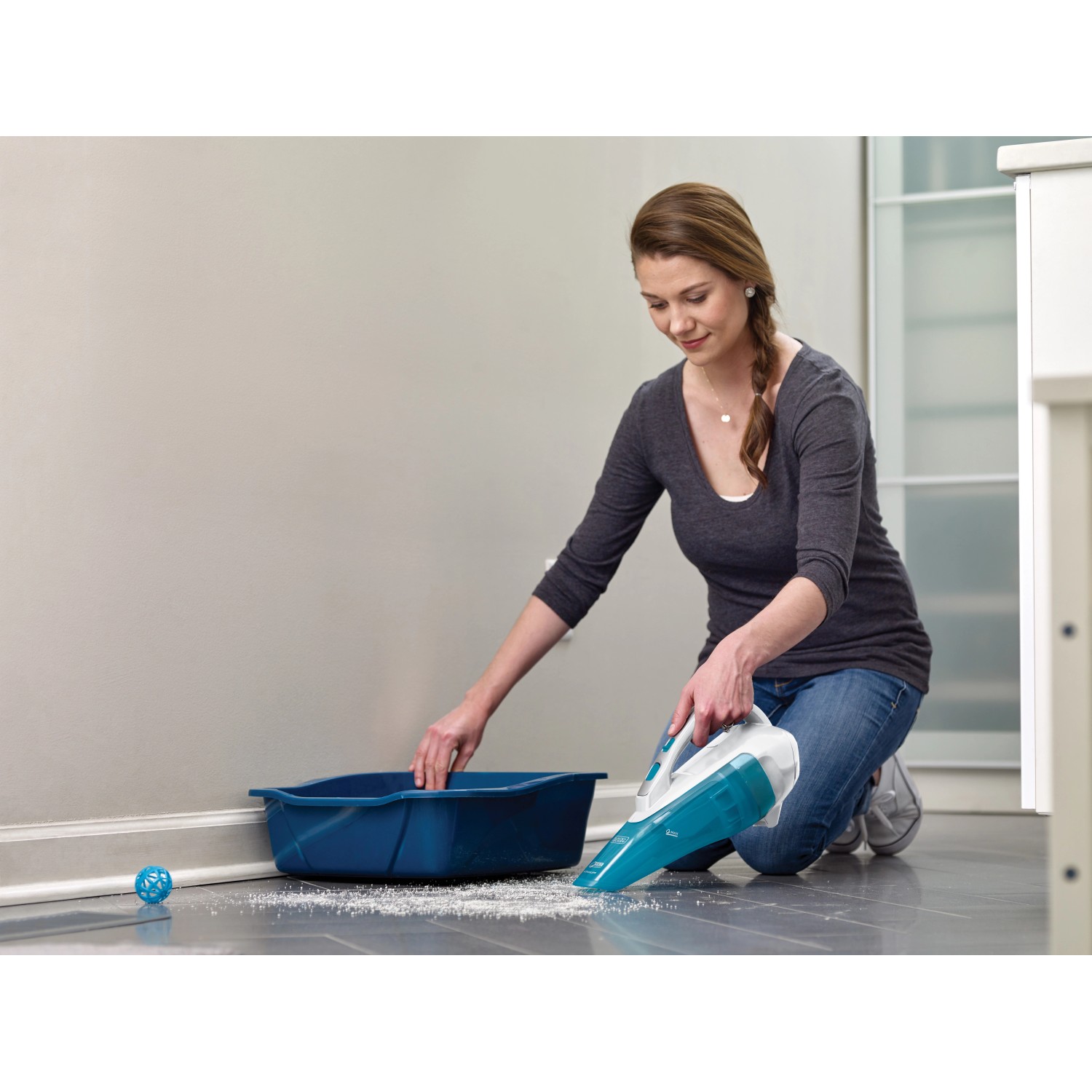 Frau saugt mit Black+Decker Akku-Handstaubsauger Flüssigkeit auf. Nass- und Trockensauger.