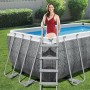 Bestway Frame Pool-Set Power Steel in Rattan-Optik mit Leiter und Frau im Pool.