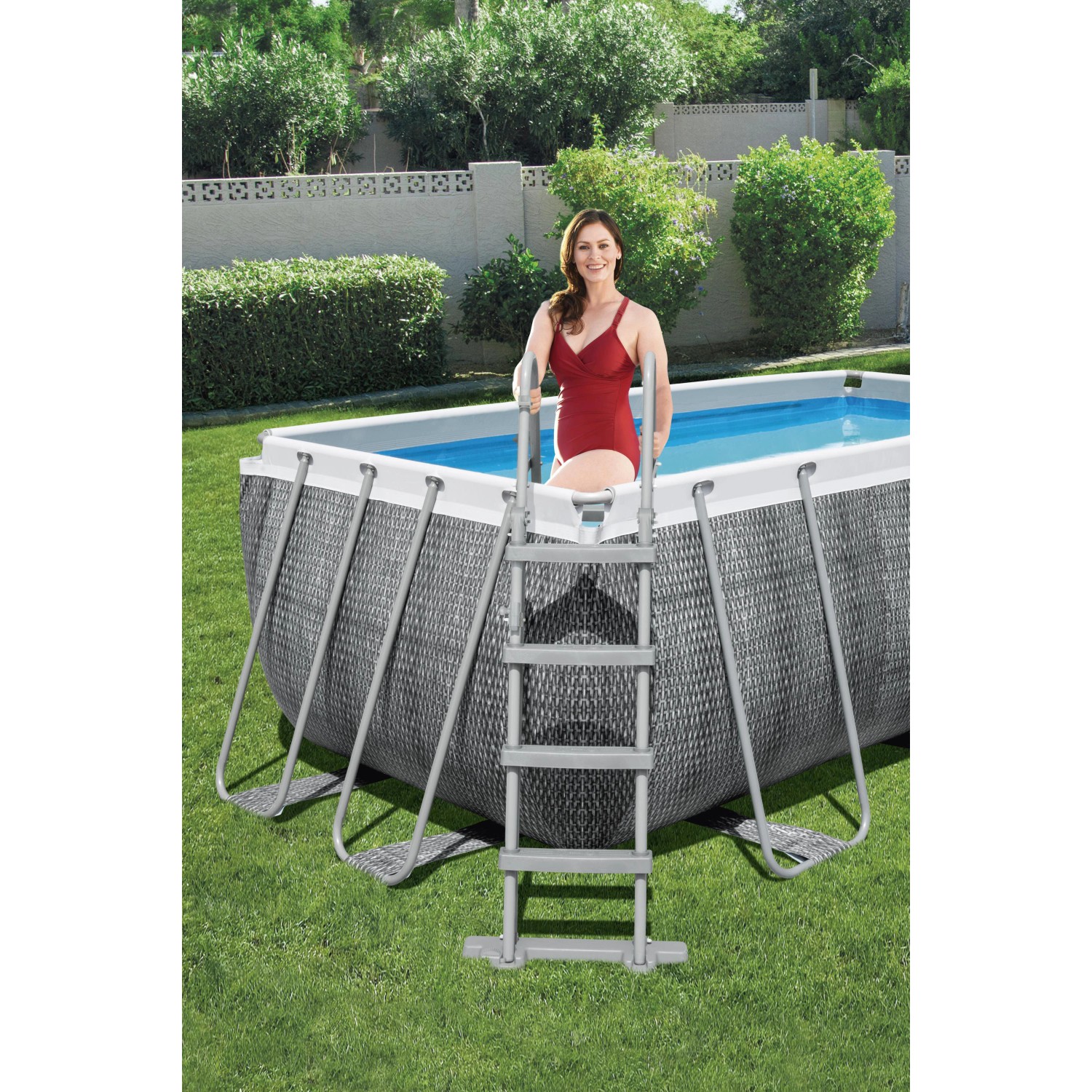 Bestway Frame Pool-Set Power Steel in Rattan-Optik mit Leiter und Frau im Pool.
